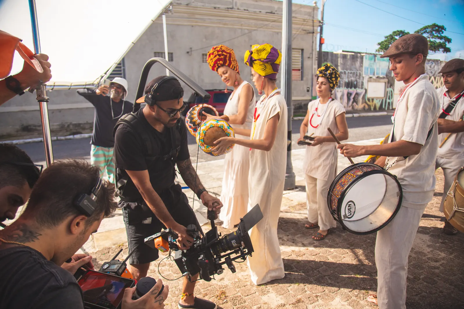 Filming drummers and dancers in traditional costumes on a street in Alagoas.